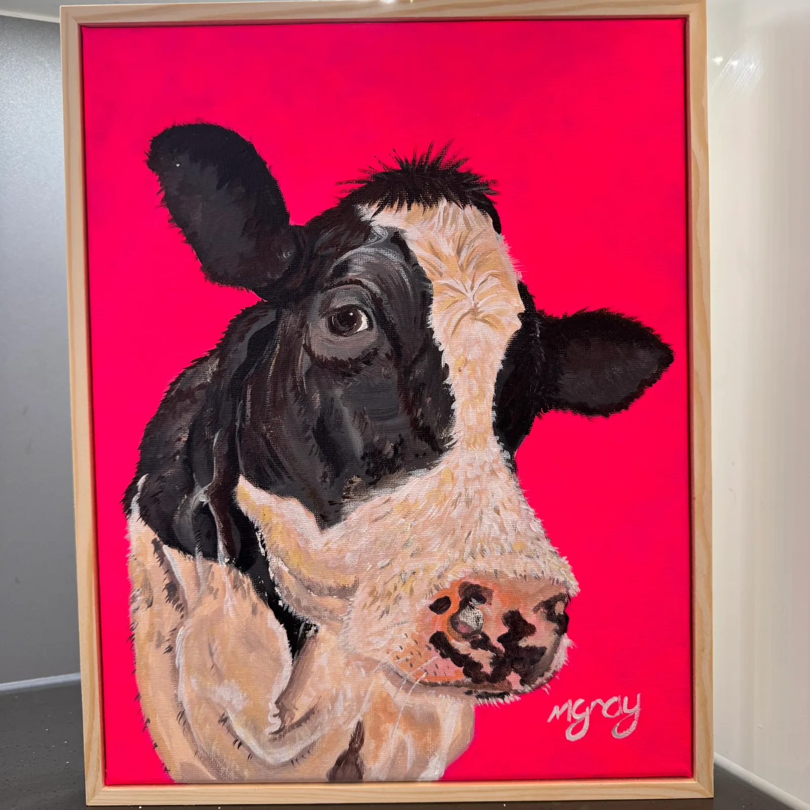 Acrylic painting of a black and white cow with a fluorescent pink background on a 28 × 35 cm box canvas and finished in